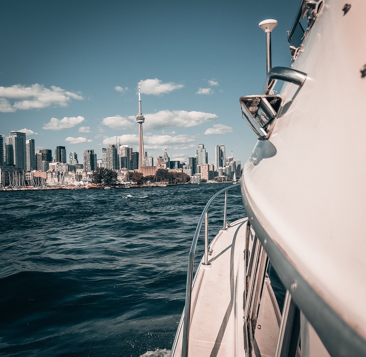 Boat cruising past the Toronto skyline on Lake Ontario