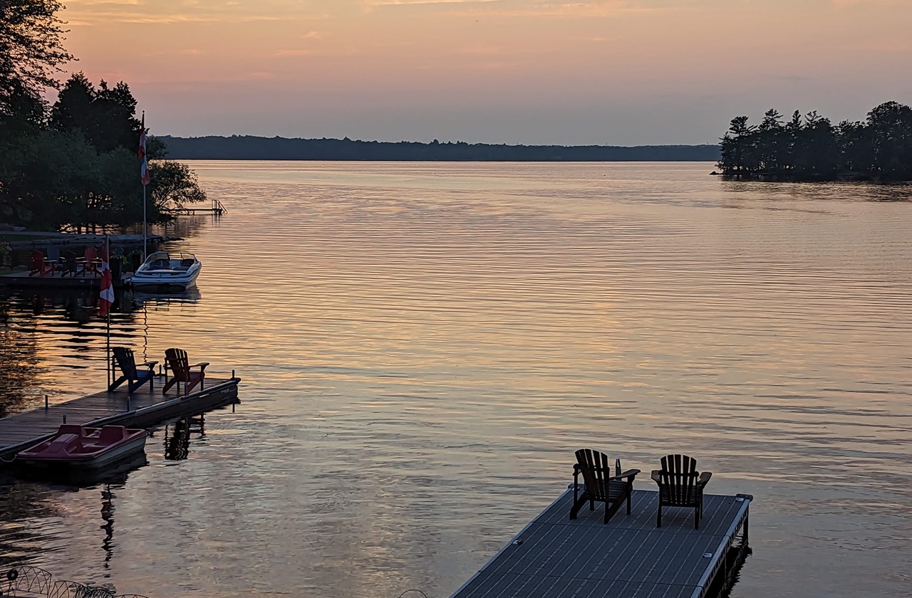 Sunset over a quiet Ontario lake with docked boats